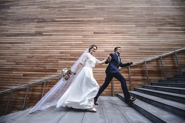 bruid en bruidegom die de trap op rennen